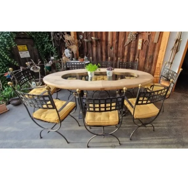 Ovaler Vollholztisch mit Glasapplikation und acht  Eisen Sessel